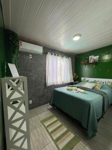 a bedroom with a bed and a green wall at Suíte Floresta - Pousada Castelo do Luar in Penha +29 photos