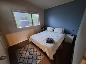 a small bedroom with a bed and a window at Fun on the Fairway in Matarangi