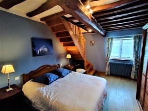 a bedroom with a large bed and a staircase at La Roselière 6 couchages in Sainte-Colombe +1 photo