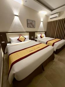 a hotel room with two beds in a room at Marina Cua Lo Hotel in Cửa Lô