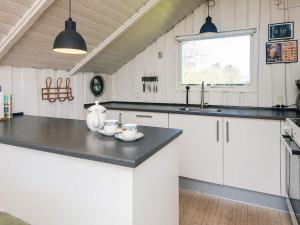 a kitchen with white cabinets and a black counter top at 4 star holiday home in Hejls in Hejls