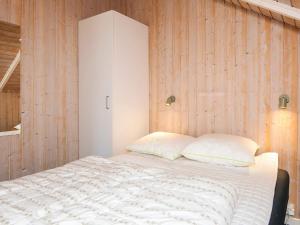 a bedroom with a bed with a wooden wall at 4 star holiday home in Hejls in Hejls