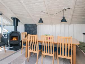 a dining room with a table and chairs and a fireplace at 4 star holiday home in Hejls in Hejls