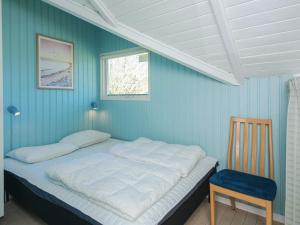 a bed in a blue room with a chair and a window at 4 star holiday home in Hejls in Hejls +16 photos