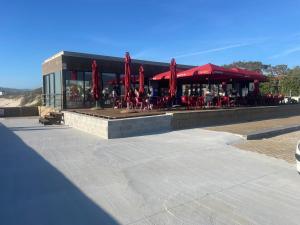 a restaurant with red tables and red umbrellas at Casa do Pai in Vila Praia de Âncora
