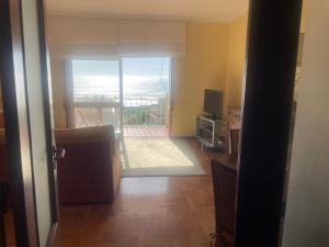 a room with a door open to a balcony with a television at Casa do Pai in Vila Praia de Âncora