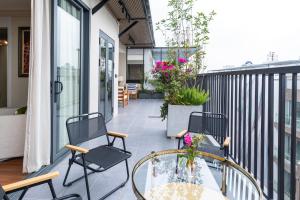 a patio with chairs and a glass table on a balcony at Well-being Home - Self-Service in Hanoi