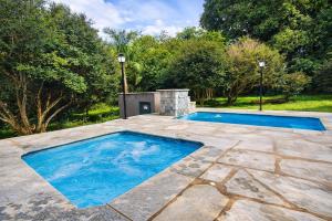 a swimming pool in a yard with a stone patio at Chalé Veredas e Buritis in Pirenópolis