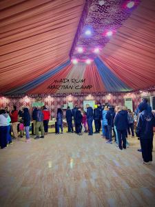 a group of people standing on a dance floor in a tent at Rum Rhal Luxury Camp in Aqaba