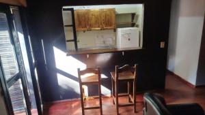 a small kitchen with two chairs and a counter top at Rincón de Esperanza in Puerto Esperanza
