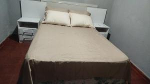 a bed in a room with two nightstands and two tables at Rincón de Esperanza in Puerto Esperanza