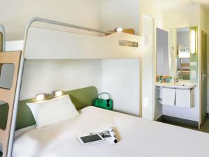 a room with a bed with a camera on it at ibis budget Augsburg Gersthofen in Augsburg +41 photos
