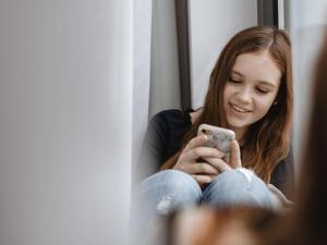 a young girl is looking at her cell phone at ibis budget Berlin Hoppegarten in Hoppegarten
