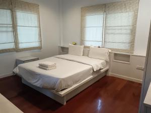 a bedroom with a bed with white sheets and windows at jomtien 5BR villa in Pattaya South +4 photos