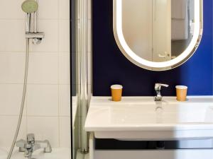 a bathroom with a sink and a mirror at ibis Rodez Centre in Rodez