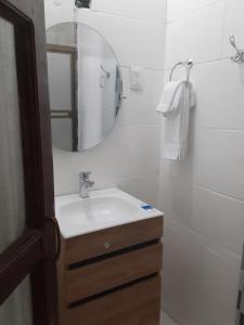 a white bathroom with a sink and a mirror at Apartamento Vita in Managua