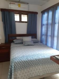 a bedroom with a bed with blue curtains at Apartamento Vita in Managua