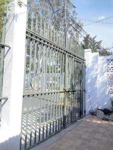 a gate on the side of a white fence at Apartamento Vita in Managua