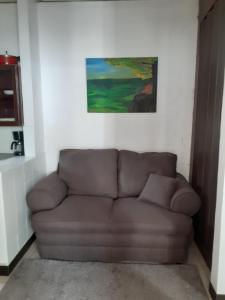 a brown couch in a room with a painting on the wall at Apartamento Vita in Managua