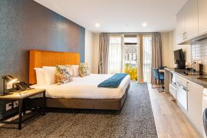 a hotel room with a bed and a kitchen at Quest Queenstown Apartments Remarkables Park in Queenstown