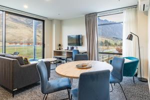 a living room with a couch and a table and chairs at Quest Queenstown Apartments Remarkables Park in Queenstown