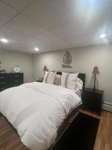 a large white bed with white sheets and pillows at Beacon Hudson Hideaway in Beacon