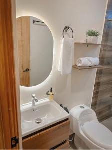 a bathroom with a sink and a toilet and a mirror at CityZen Apartahotel in Florencia +18 photos