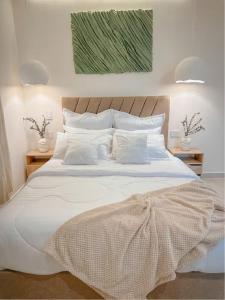 a bedroom with a large bed with white sheets and pillows at CityZen Apartahotel in Florencia