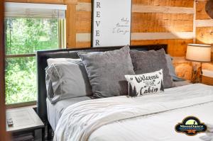 a bedroom with a bed with gray pillows and a window at Dogwood Hills in Nashville