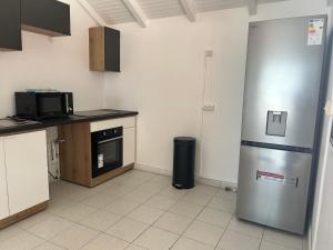 a kitchen with a refrigerator and a microwave at Le Palm Loft in Pointe-à-Pitre