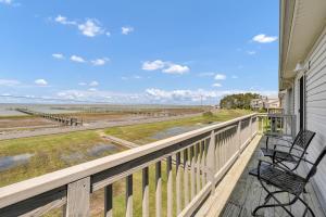 two chairs on a balcony looking out at the beach at Sunny Shack in Black Point Landing