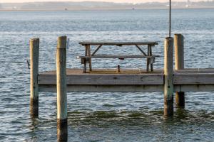 a wooden dock with a picnic table on the water at Sunny Shack in Black Point Landing