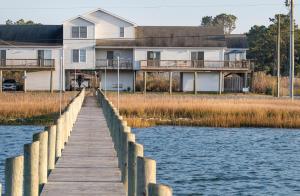 a house on the water with a wooden dock at Sunny Shack in Black Point Landing