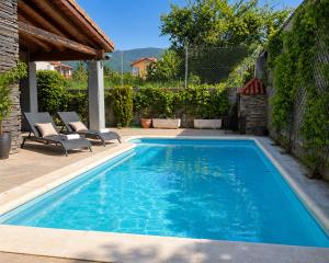a swimming pool in a yard with two lounge chairs at Vistapeña in Piedrahita