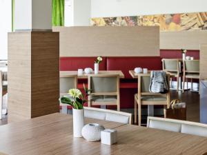 a table with a vase with flowers on top of it at ibis Berlin Dreilinden in Kleinmachnow