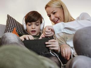 a woman listening to a little boy with headphones at ibis Berlin Dreilinden in Kleinmachnow