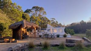 a boat parked in a field with a hut at Shipwrecked Oasis Ocean Bay Getaway PL in Fingal
