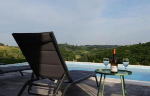 a bottle of wine sitting on a table next to a chair at Amazing Home In Banfi in Štrigova +16 photos