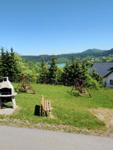 a park with a grill and a bench in the grass at Domek Bieszczady Wolkowyja 2 nad Solina in Wołkowyja