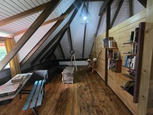 a attic room with a bench and a table and books at Villa Fareatai in Ataiti