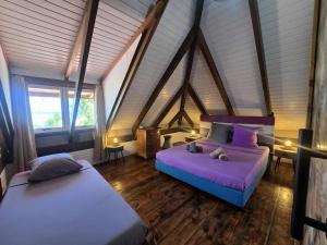 a bedroom with two beds in a attic at Villa Fareatai in Ataiti