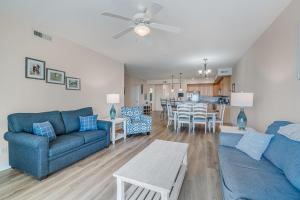 a living room with a blue couch and a table at Sunset Bay Villa 110 - Hawks Nest in Chincoteague