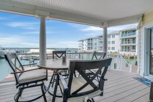 a patio with a table and chairs on a deck at Sunset Bay Villa 110 - Hawks Nest in Chincoteague +34 photos