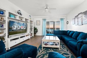 a living room with a blue couch and a tv at Sunset Bay Villa 209 in Chincoteague