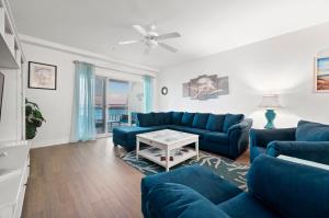 a living room with blue couches and a table at Sunset Bay Villa 209 in Chincoteague