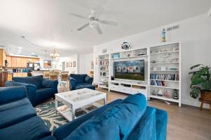 a living room with blue couches and a tv at Sunset Bay Villa 209 in Chincoteague