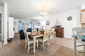 a dining room and living room with a table and chairs at Sunset Bay Villa 209 in Chincoteague +31 photos