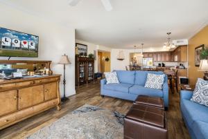 a living room with a blue couch and a kitchen at Sunset Bay Villa 216 in Chincoteague