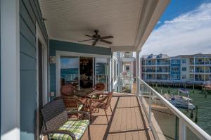 a porch with chairs and a table and a ceiling fan at Sunset Bay Villa 216 in Chincoteague