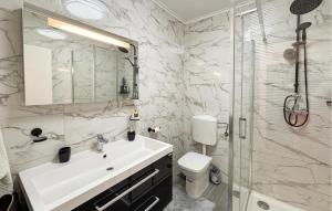 a bathroom with a sink and a toilet and a shower at Lovely Home In Podhum With House A Panoramic View in Podhum